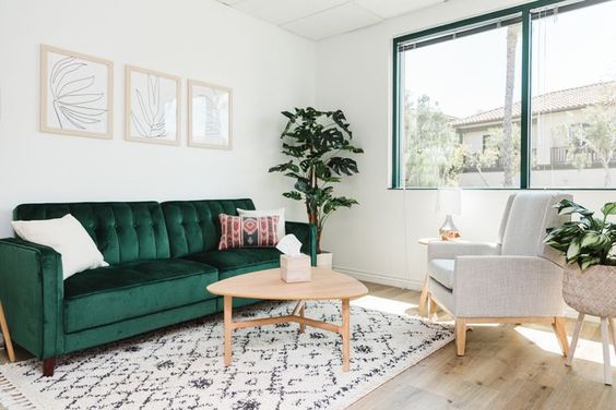 Chắc sofa màu xanh rêu nổi bật trong căn phòng có màu trắng chủ đạo